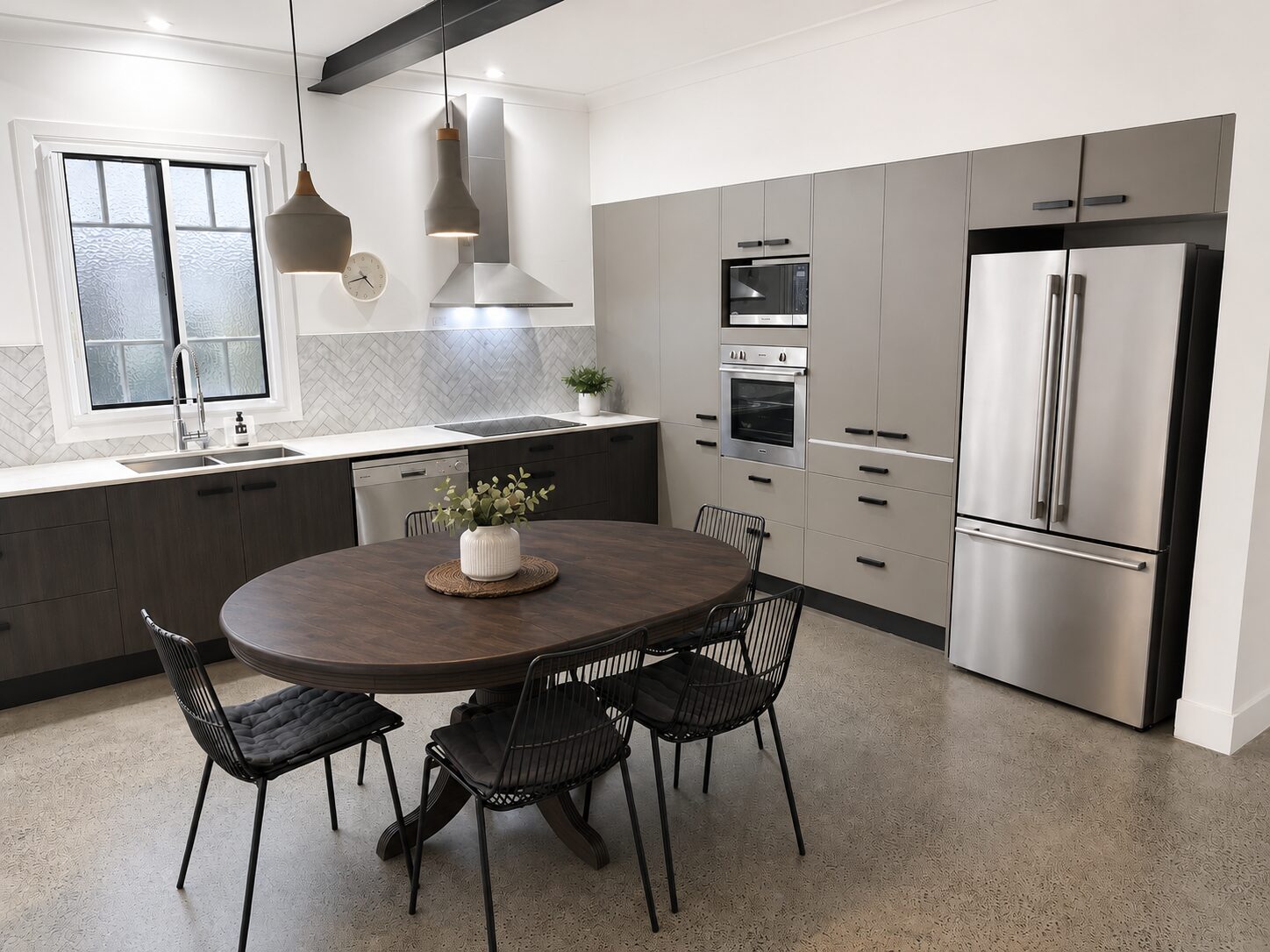 The finished kitchen and dining: two-tone joinery and stone benchtops